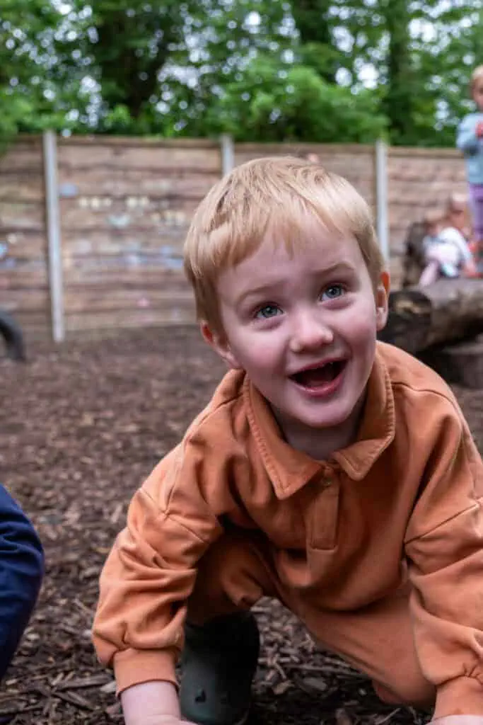Exciting outdoor play area at Thrive Childcare with children engaging in activities on natural wood chip ground.