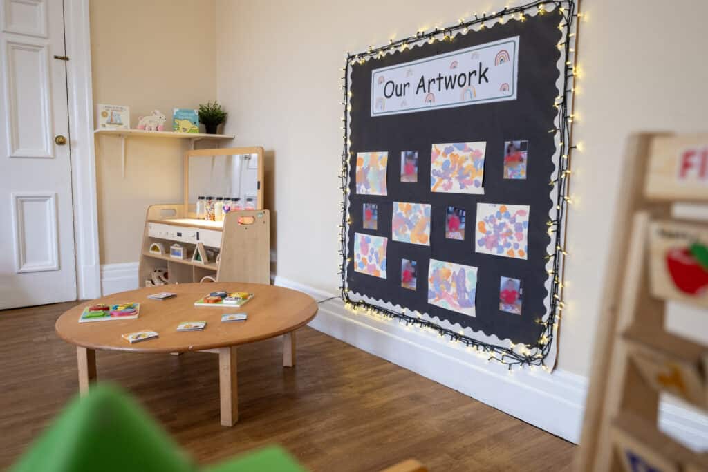 1. Bright and welcoming early childhood education room at Thrive Childcare with artwork display and play area for young children.