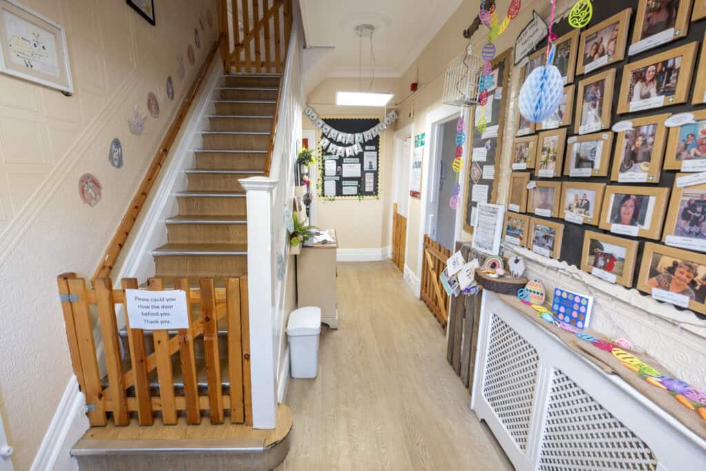 Bright nursery hallway at Thrive Childcare with colourful decorations, photo displays, and a welcoming environment for early childhood education and development.