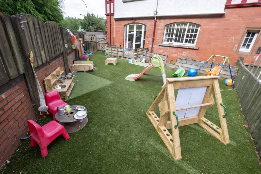 Colourful outdoor play area at Thrive Childcare with swings, slides, sandboxes, and activity stations, designed for children's fun and learning in a safe environment.
