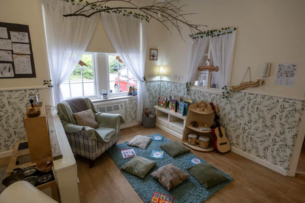 Comfortable early years classroom at Thrive Childcare, featuring cozy seating, children's books, musical instruments, and calming decor to support learning and development for young children.
