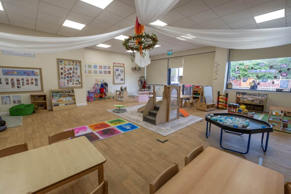 Bright and welcoming indoor play area at Thrive Childcare, featuring engaging toys, learning spaces, and soft play for children’s development and fun, emphasising high-quality childcare services.