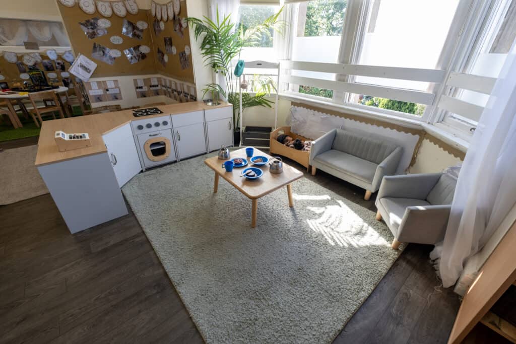 Bright and welcoming childcare play area with cosy seating, activity toys, and large windows providing natural light, perfect for early childhood learning and social development at Thrive Childcare.