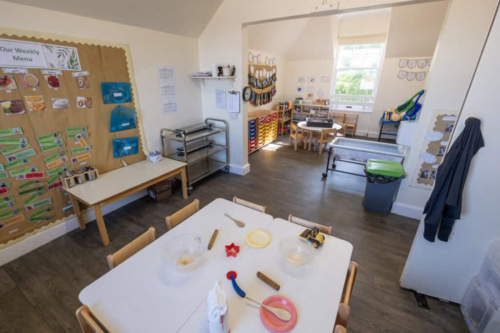 Bright and welcoming childcare classroom at Thrive Childcare featuring educational displays, children's artwork, and versatile play and learning areas for early childhood development in a safe environment.