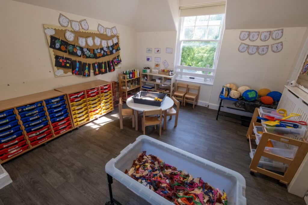 Bright, inviting childcare room at Thrive Childcare with colourful storage, craft materials, and safe play areas designed for early childhood development and learning.