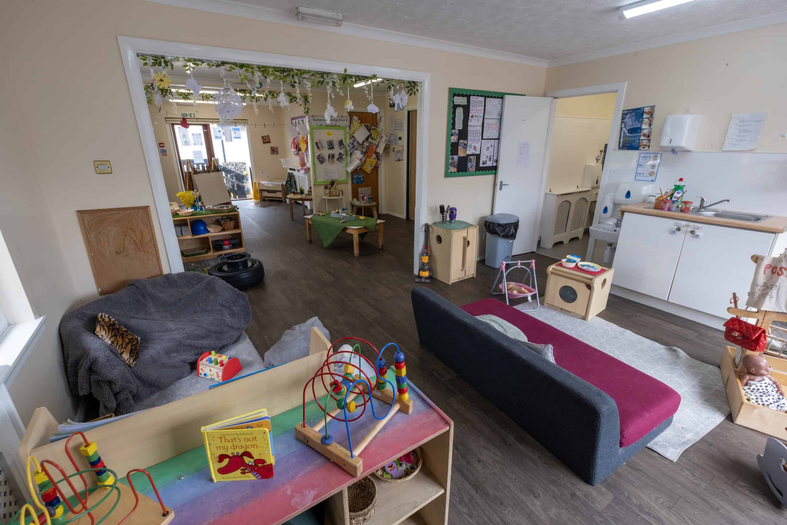 Bright and welcoming childcare classroom with toys, reading corner, and play areas at Thrive Childcare, creating a safe environment for early childhood development and learning.