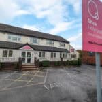 Bright exterior of Thrive Childcare centre at Shaw Holyrood Nurseries with parking area and prominent pink signage showcasing childcare and early education services.