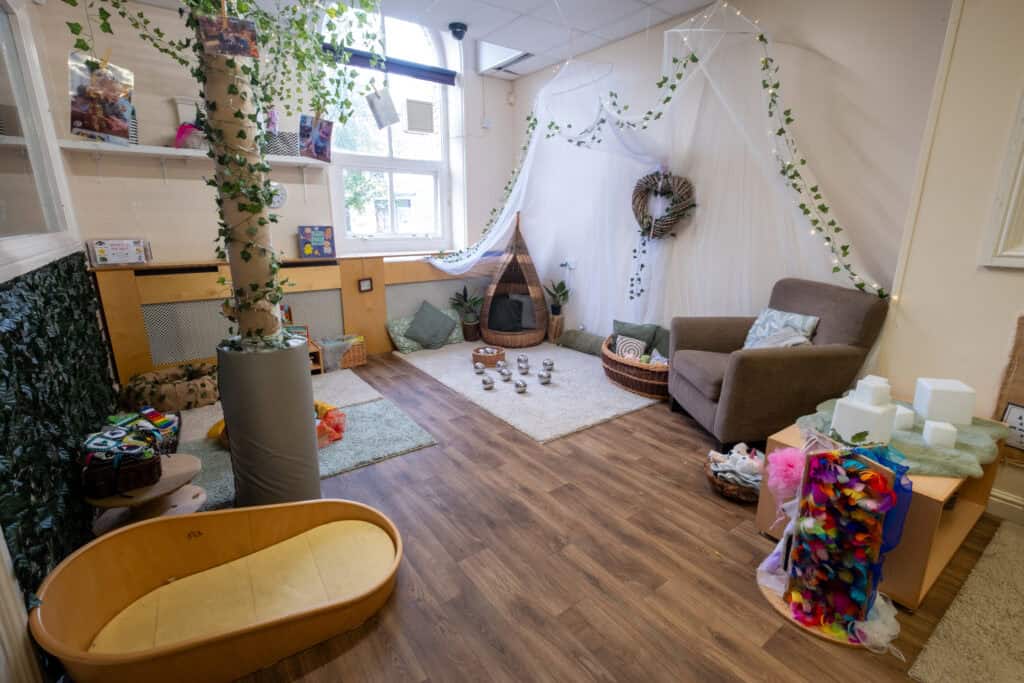 Cozy indoor play area at Thrive Childcare featuring natural decor, soft rugs, and comfortable seating for children, creating a nurturing environment for early childhood development and play.