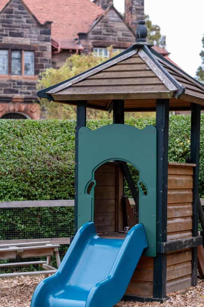Bright outdoor play area with a wooden toddler slide at Thrive Childcare, promoting safe and fun early childhood development. Ideal for children's outdoor activities and socialising.