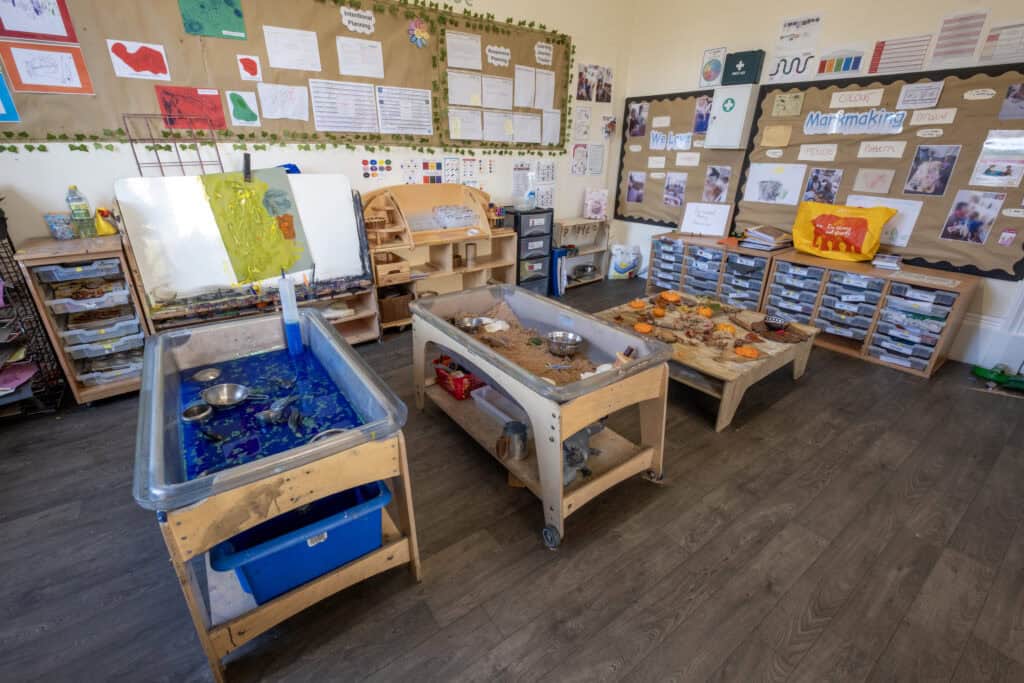 Bright indoor play area at Thrive Childcare with sensory tables and educational displays, supporting early childhood development and learning through sensory activities.