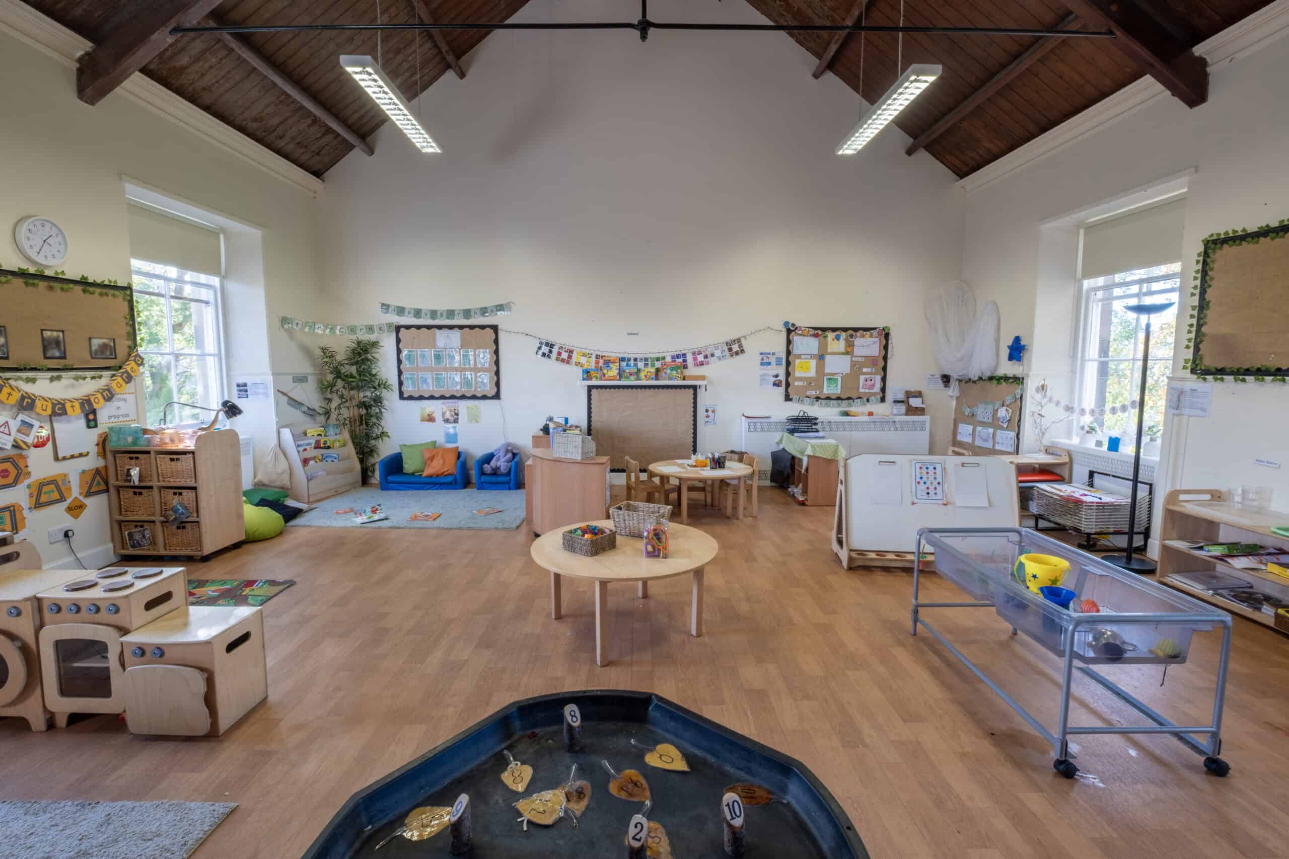 Bright and spacious indoor play area at Thrive Childcare, featuring colourful educational toys, cosy relaxation zones, and engaging activity stations designed for early childhood development and learning.