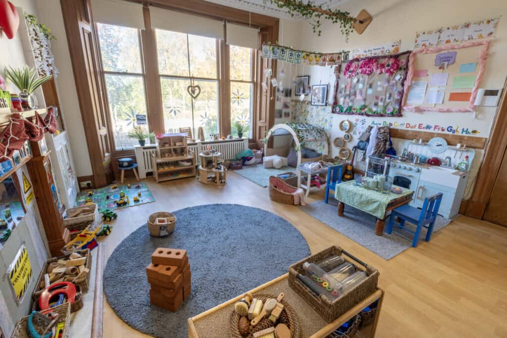 Soft play and toy area in a colourful early childhood classroom at Thrive Childcare, with natural light, educational displays, and children's toys, fostering creative learning and development.