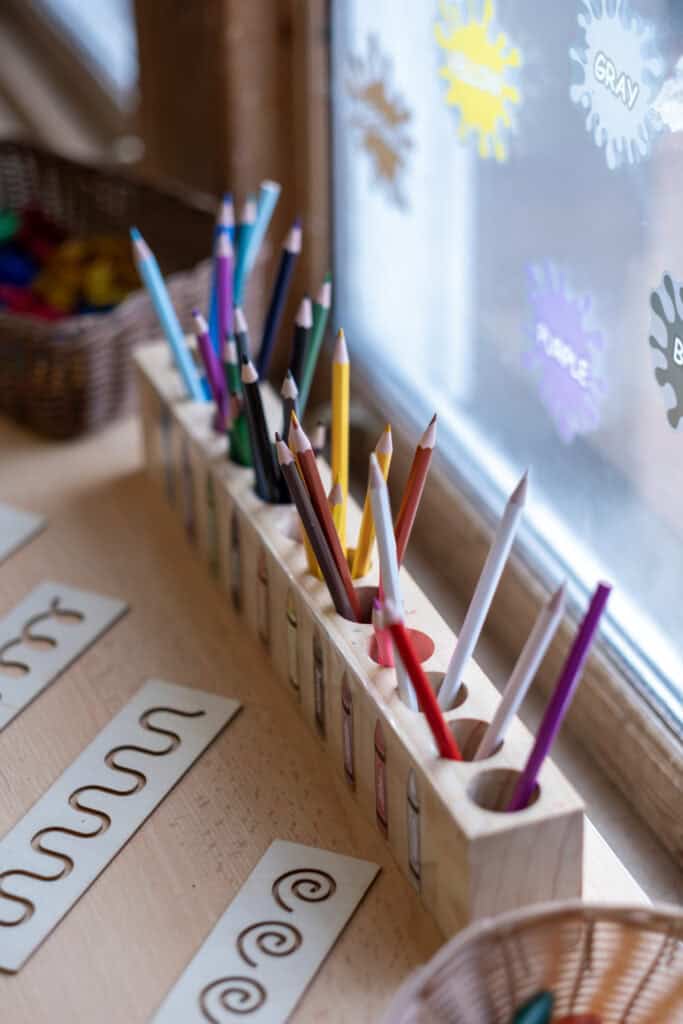 1. Colour pencils in a wooden holder on a classroom windowsill, promoting creativity and learning for children at Thrive Childcare.