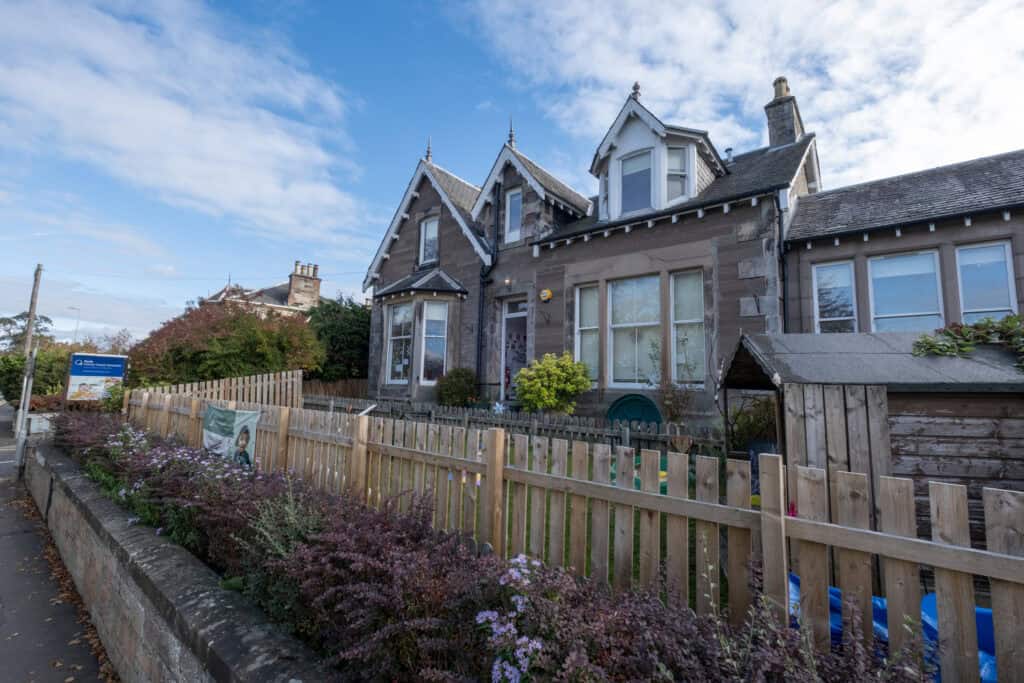 Colourful Victorian-style childcare building with outdoor play area and garden, offering a nurturing and safe environment for young children, dedicated to early childhood education and care.