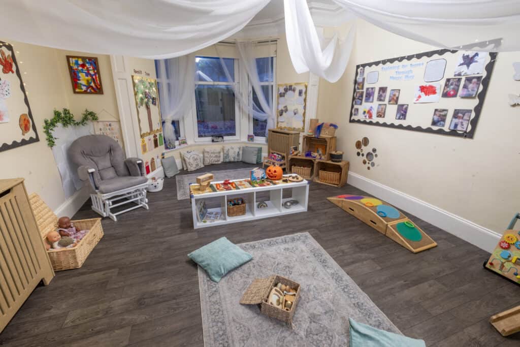 Bright, cosy indoor childcare playroom with toys, soft cushions, and educational displays, ideal for early childhood development at Thrive Childcare.