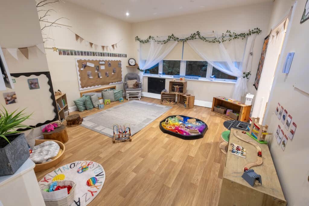 Bright and welcoming childcare playroom at Thrive Childcare with toys, reading area, and cosy corners for children's development and learning.