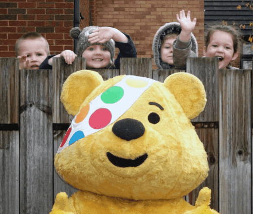 Colourful children's mascot and happy kids at Thrive Childcare, fostering a fun and engaging early childhood education environment in the UK.
