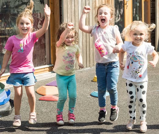 Bright happy children playing outdoors at Thrive Childcare, emphasising fun, learning, and nurturing environment for early childhood development in the UK.
