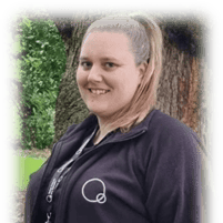 Bright smiling childcare worker outdoors at Thrive Childcare, showcasing caring staff and engaging environment for children's development and learning.
