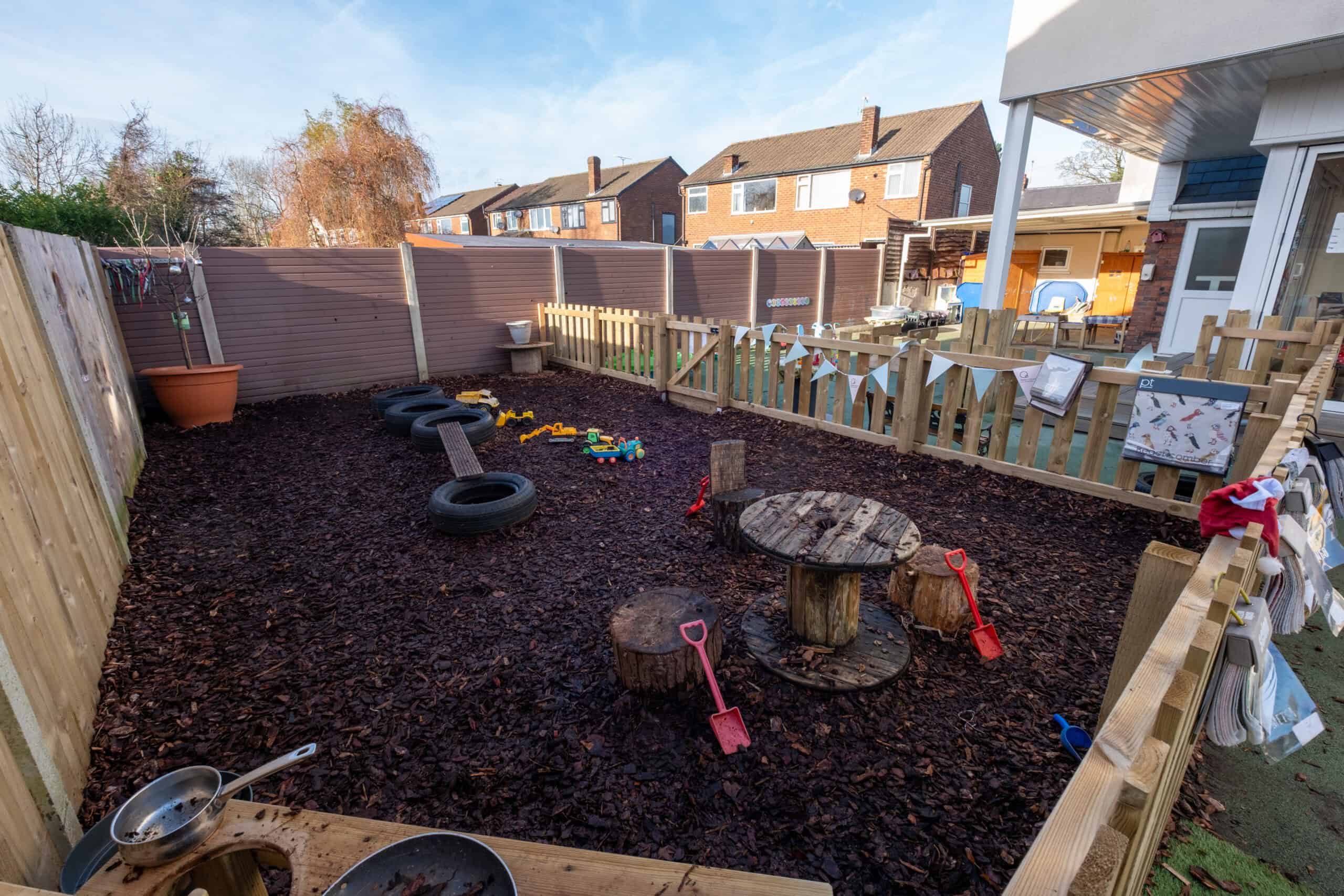 Bright outdoor play area with natural elements and toys for children.