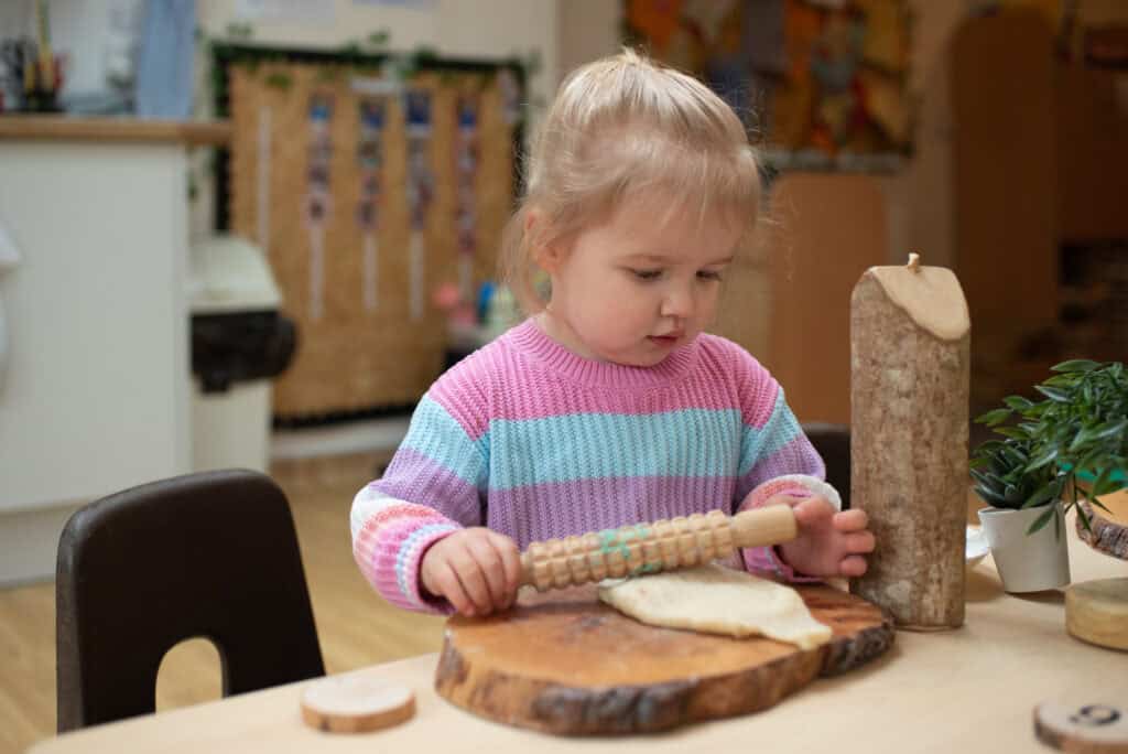 1. Young girl baking bread in a childcare centre, engaging in fun and educational preschool activities at Thrive Childcare.