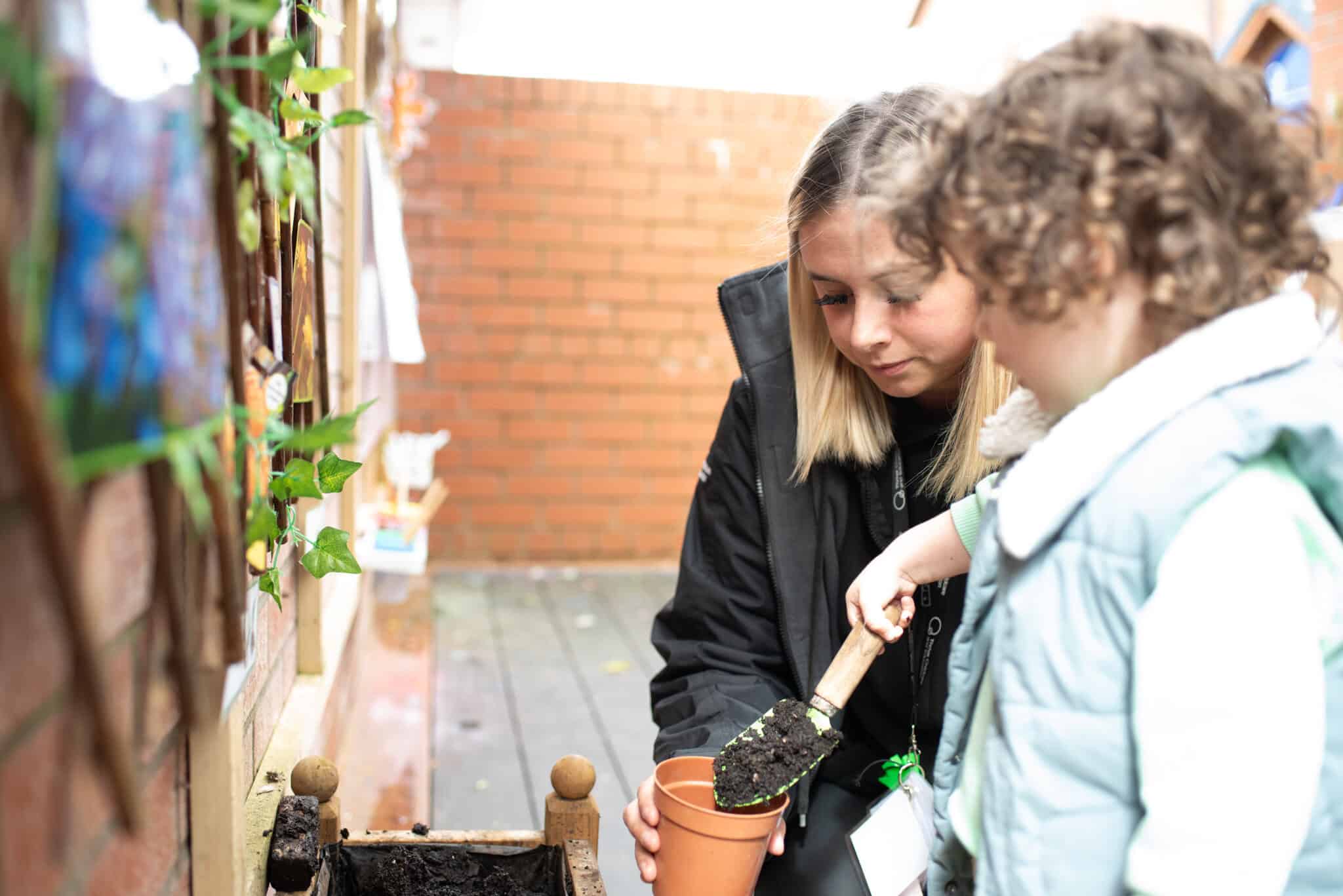Planting activity at Thrive Childcare, outdoor learning environment for preschool children, nurturing creativity and environmental awareness, professional staff guiding young learners, colourful brick background.