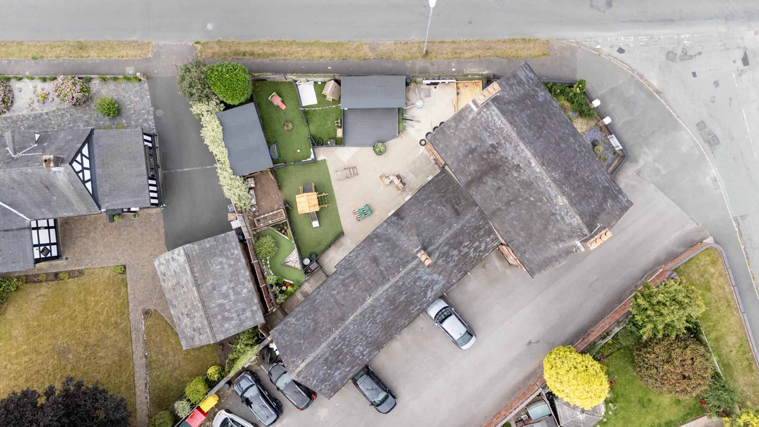 Bright aerial view of Thrive Childcare outdoor play area with engaging toys, green spaces, and secure fencing, offering a safe, nurturing environment for children’s play and development.