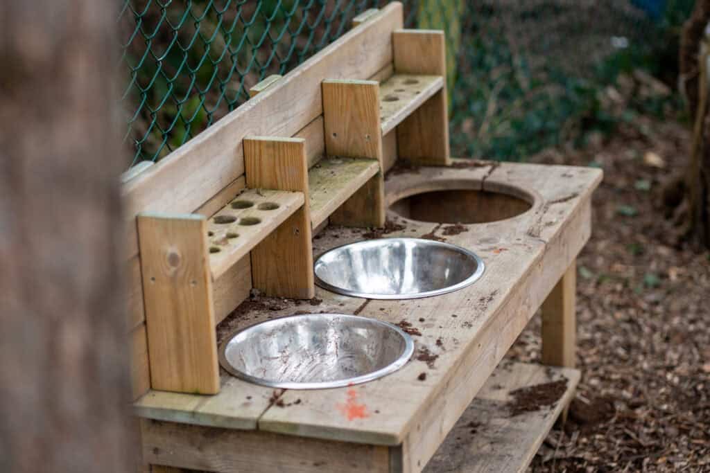 Outdoor children's activity station with sinks and storage.