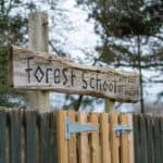 Outdoor forest school sign with rustic wooden design at Thrive Grosvenor House childcare centre.