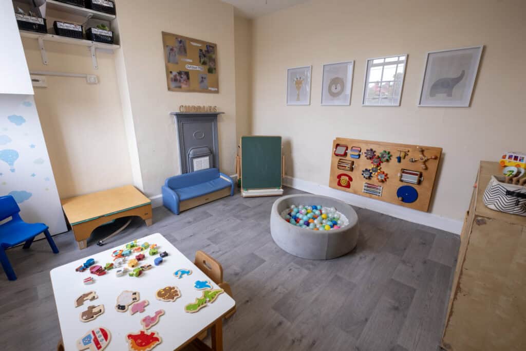 Bright indoor baby playroom at Thrive Childcare with soft play, educational toys, sensory ball pool, and child-friendly artwork, fostering a safe and engaging environment for early childhood development.