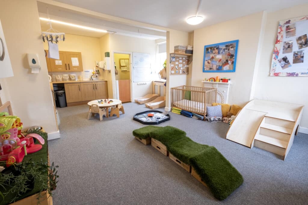 Bright indoor toddler playroom at Thrive Childcare with age-appropriate toys, soft play mats, and cozy nursery corner for early childhood development and learning.