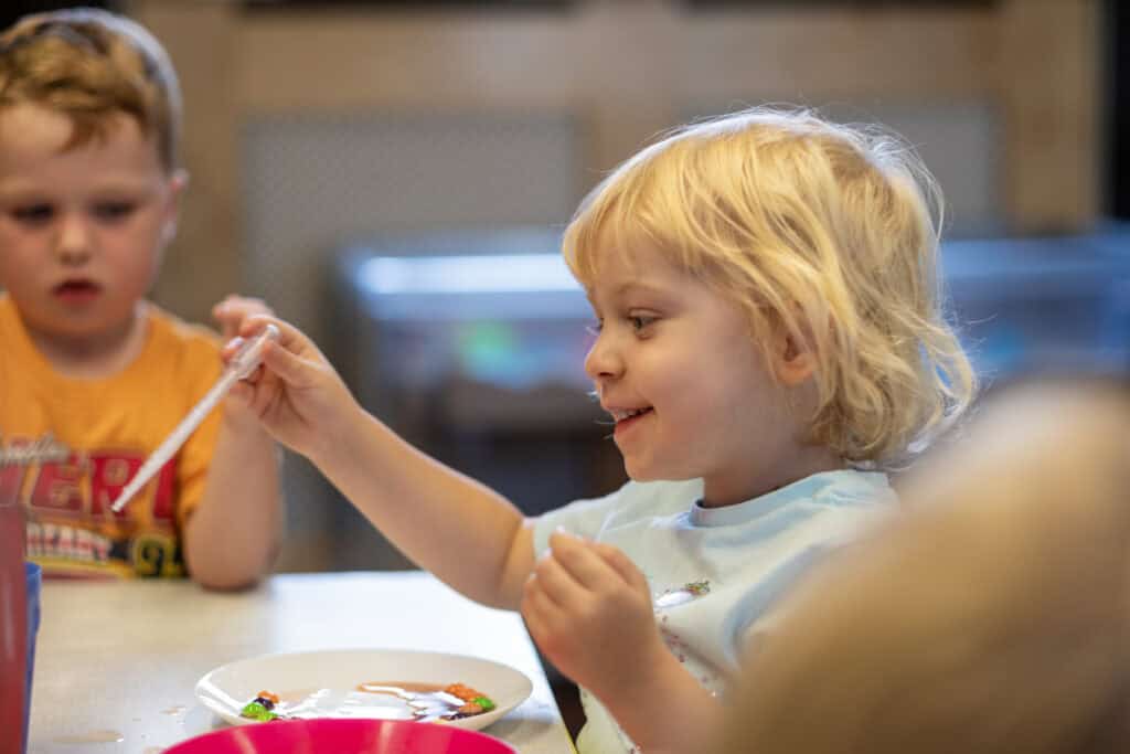 Bright young children engaging in creative play and snack time at Thrive Childcare, promoting early childhood development, social skills, and nurturing care in a safe learning environment.