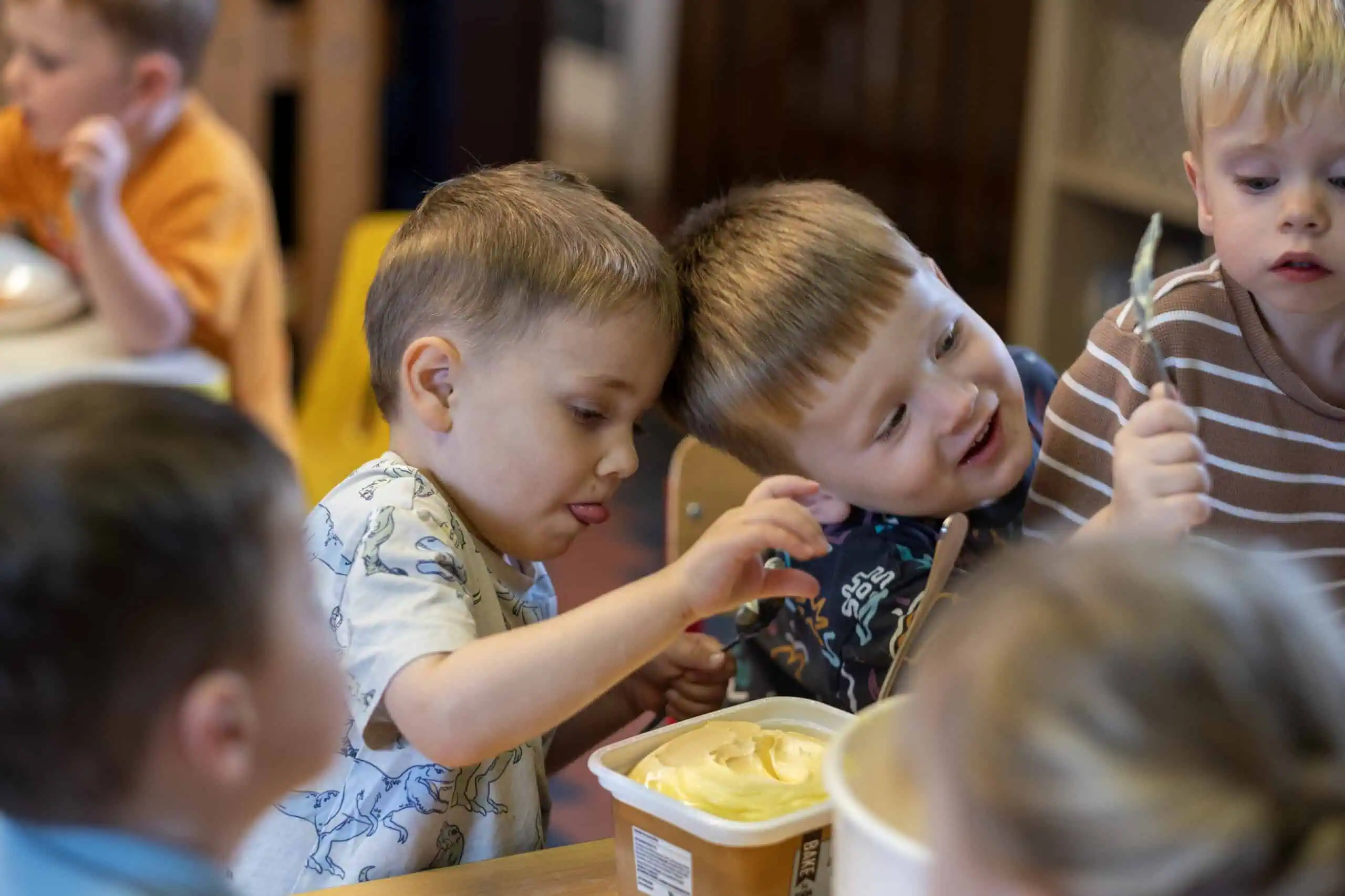 Children enjoying a nutritious snack time at Thrive Childcare, fostering social skills and healthy eating habits in a caring environment.