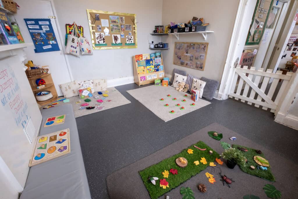 1. Colourful indoor childcare play area with educational toys, cosy cushions, and nature-themed decorations for children's learning and exploration at Thrive Childcare.