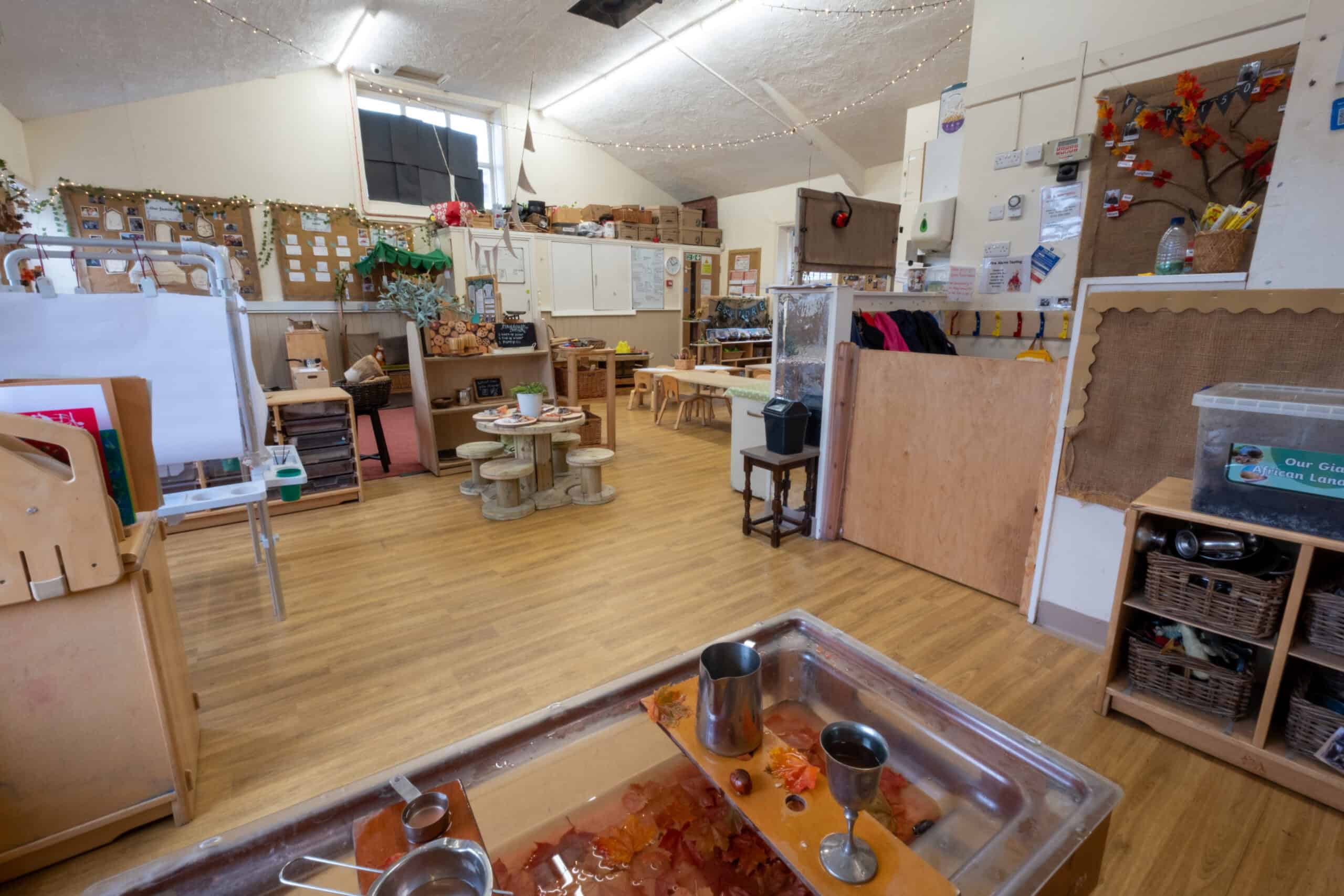 Bright and welcoming indoor play area at Thrive Childcare, featuring wooden furniture, educational toys, and creative activity stations for children's development and fun.