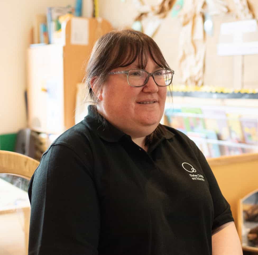 Happy childcare professional at Thrive Childcare, showcasing a caring environment for early childhood education and development in a welcoming nursery setting.