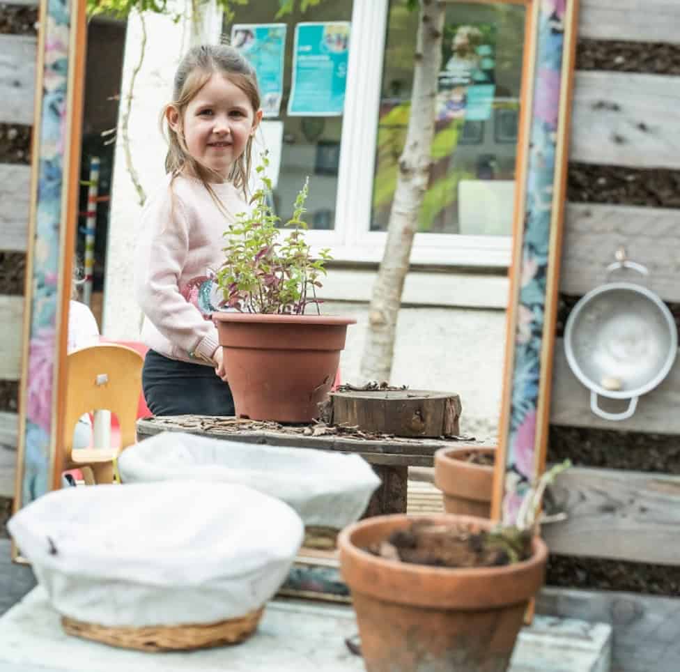 Freshly outdoors at Thrive Childcare, a little girl engages with gardening activities, promoting outdoor play and early childhood development in a caring, safe environment.