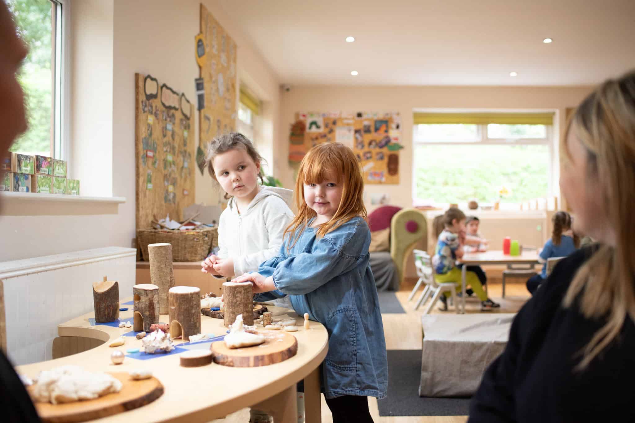 Brightly lit classroom at Thrive Childcare with young children engaging in creative play and learning activities, fostering social skills and early childhood development in a safe, nurturing environment.