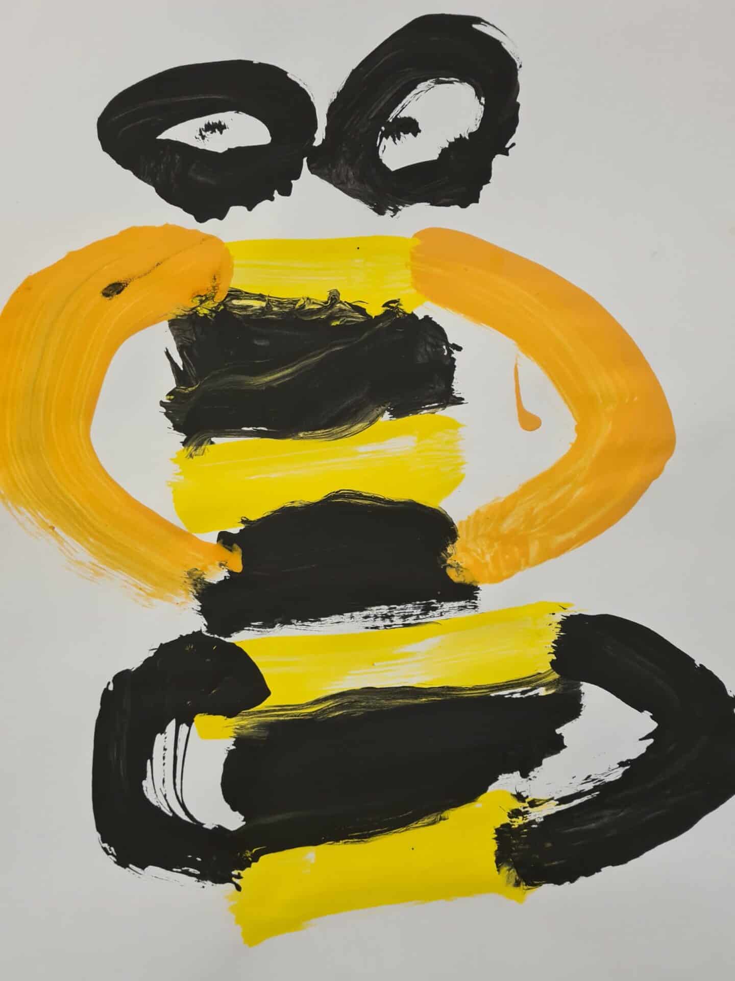 Colourful children's artwork created with bold black, yellow, and orange brush strokes on a white background, showcasing creativity and artistic expression for early childhood development.
