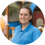 Bright smiling childcare worker in blue uniform at Thrive Childcare centre, providing caring early childhood education and nurturing environment for children.
