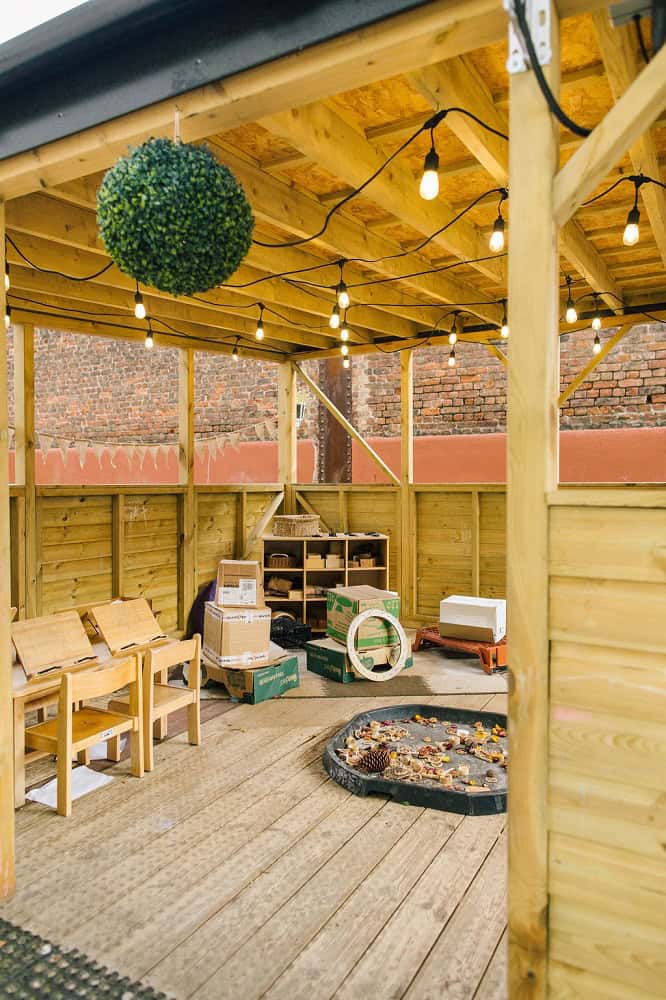 Bright outdoor play area with wooden fencing and string lights, ideal for preschool children at Thrive Childcare. Safe, engaging space designed for early childhood development and outdoor learning.