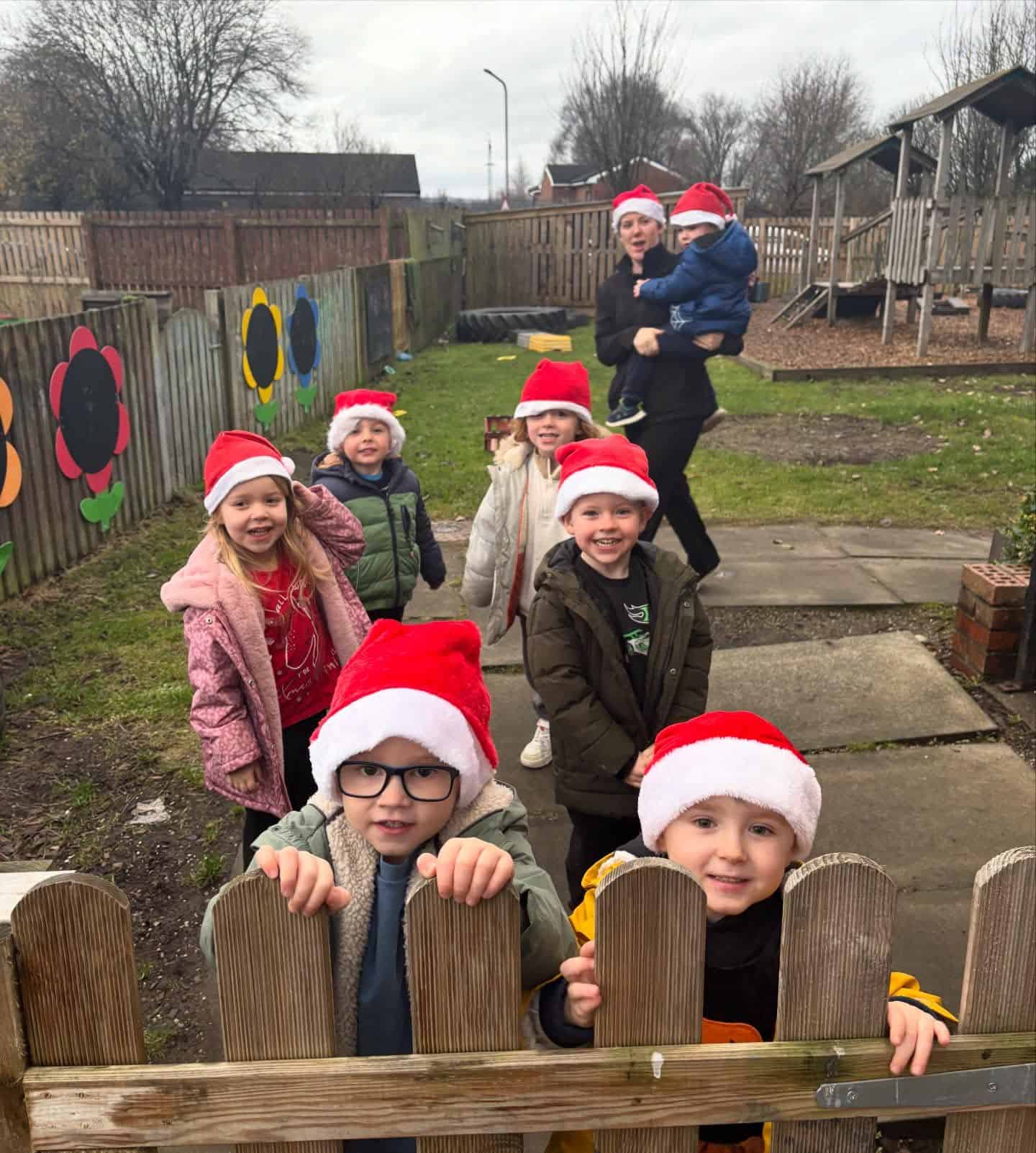 Happy children wearing Santa hats playing outdoors at Thrive Childcare during the Parent Noticeboard event.
