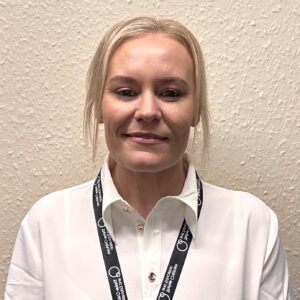Portrait of Gemma Price, a childcare professional at Thrive Childcare, smiling in her work uniform, representing caring and dedicated early childhood education.