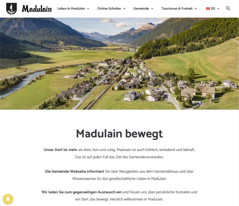 1. Encantador pueblo en los Alpes suizos, rodeado de verdes laderas y un río.