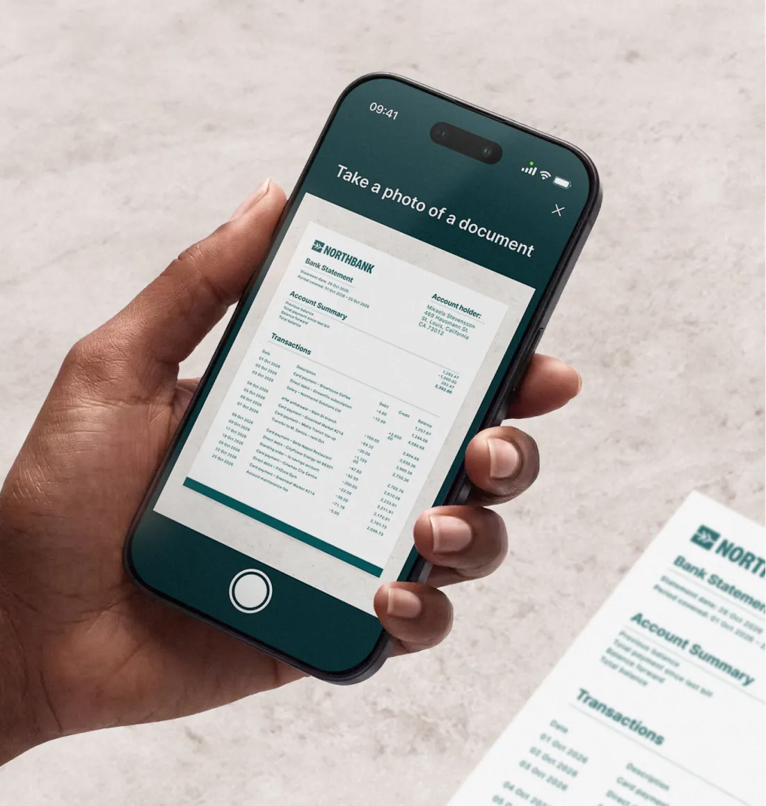 A hand holding a phone whose camera frames a Northbank bank statement, with the prompt "Take a photo of a document"
