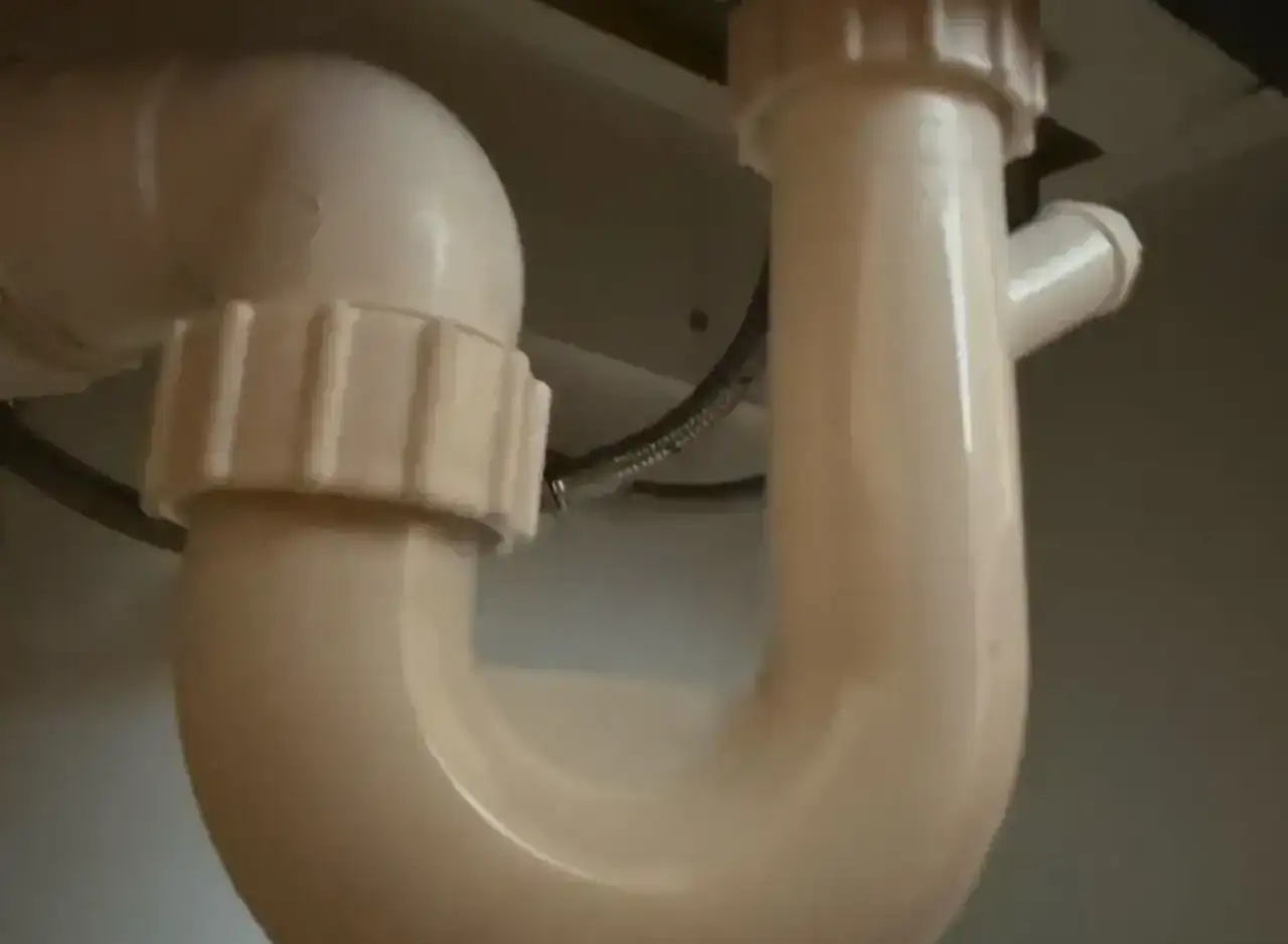 Basin waste trap under sink, plumbing repair, Richmond.
