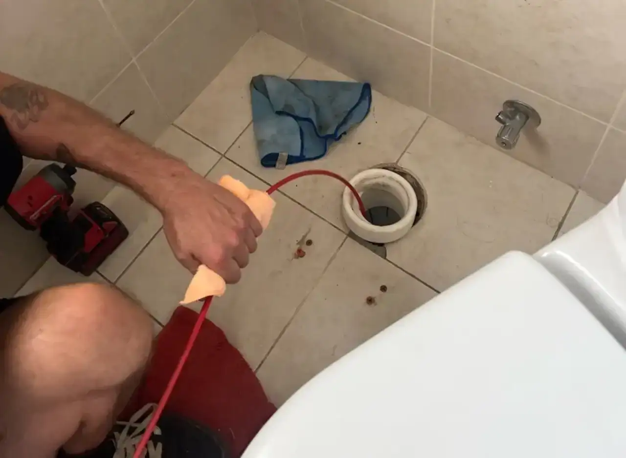 Technician repairing sanitary drainage pipe at South Yarra property.