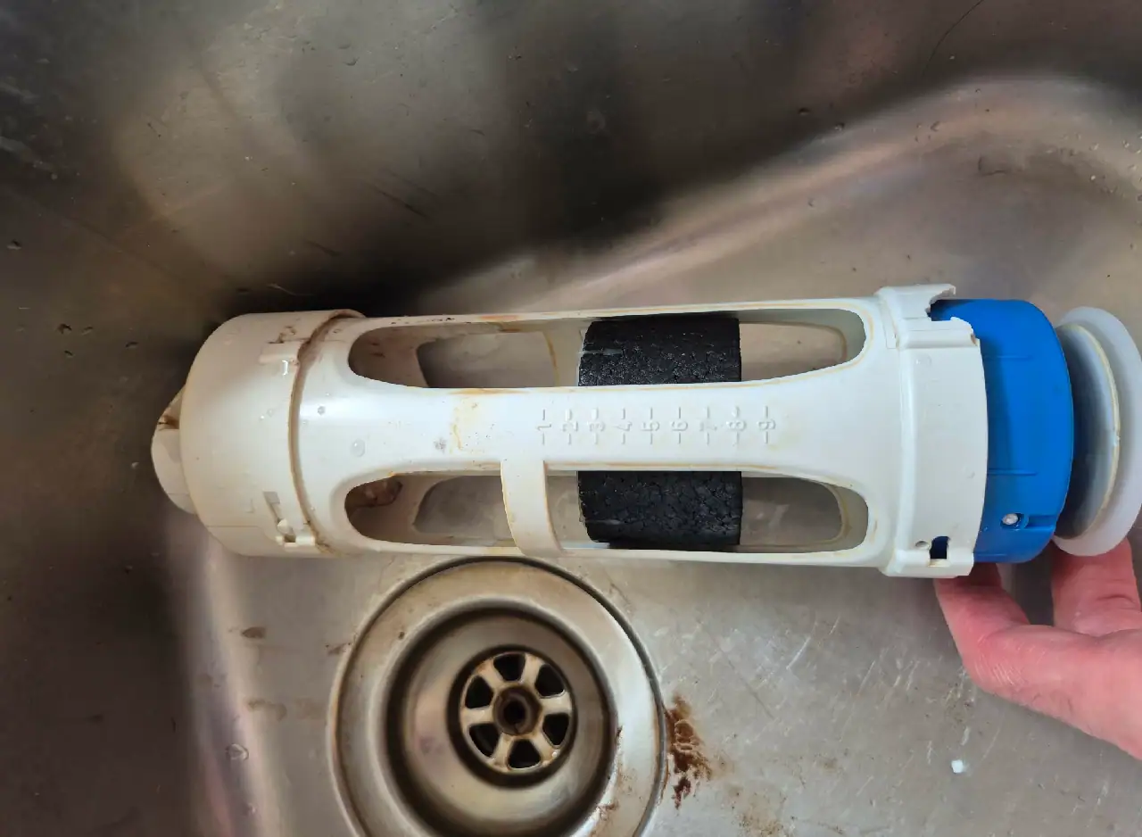 Drainage filter cleaning tool in kitchen sink for plumbing maintenance.