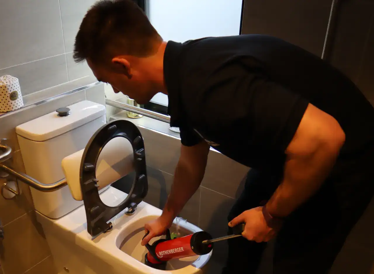 Plumber fixing a blocked toilet in a Keysborough bathroom.