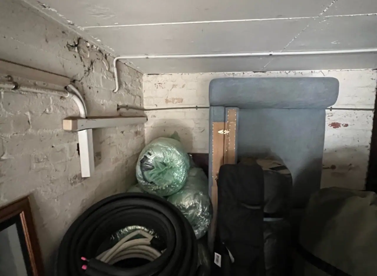 Storage area with plumbing pipes and tools for maintenance and repairs.
